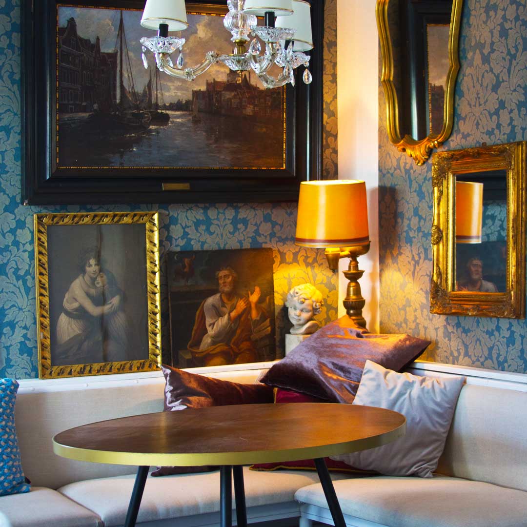 Gemütliche Sitzecke im Café Zeitreisen mit Sofa, Tisch und klassischen Gemälden